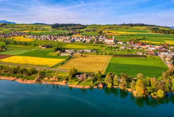 Nottwil town and idyllic swiss landscapes with blooming canola fields on Lake Sempach, Switzerland