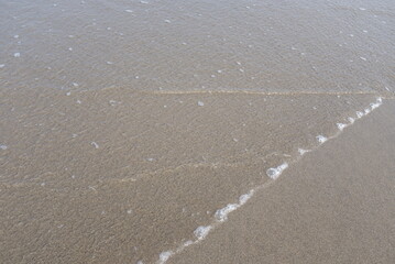 海辺にて 波打ち際の水と砂浜 夏の水遊び