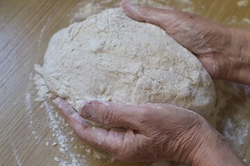 close up of a person holding a dough
