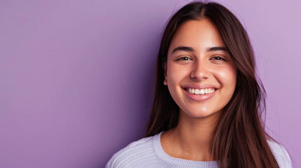 Fototapeta premium A woman with long brown hair is smiling and looking at the camera