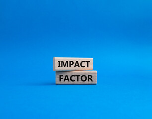Impact Factor symbol. Wooden blocks with words Impact Factor. Beautiful blue background. Business...