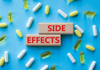 Side Effects symbol. Wooden blocks with words Side Effects. Beautiful blue background with pills....