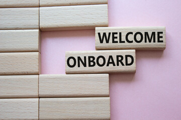 Welcome onboard symbol. Concept words Welcome onboard on wooden blocks. Beautiful pink background....