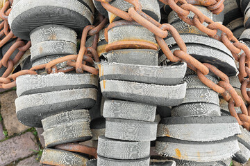gray black rubber discs with rusty steel chain used in the professional fishing industry