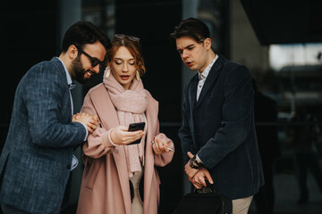 Group of young business professionals discussing project plans on a smart phone outdoors for business growth and profit strategies.