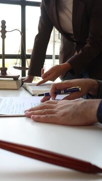 Lawyer is providing legal advice to a client. Legal advisor is discussing and explaining the terms of the legal agreement contract document before signing. Legal processing services.