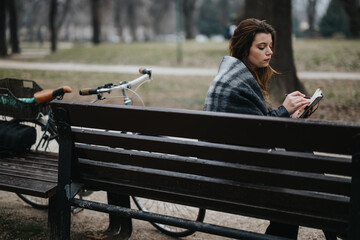 Young and stylish businesswoman enjoys a peaceful moment in the park, reflecting elegance and...