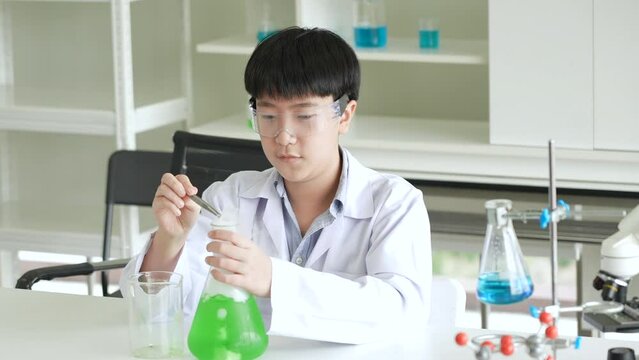 group of asian school kid studying to plastic atom model educational toy or molecular model science practical class in school laboratory