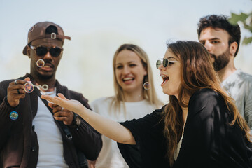 A joyful, carefree moment captured as multiracial friends laugh and blow bubbles in an urban park, embodying a relaxed, outdoor lifestyle.