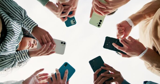 Business people, hands and networking with phone below for communication, data share or sync on a white background. Low angle or closeup of young employees on mobile smartphone, social media or app