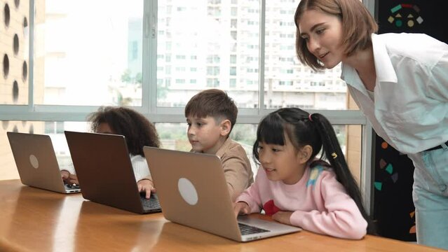 Smart teacher teaching and looking student using laptop at classroom. Professional instructor explained about programing engineering code or prompt while studying and learning program. Erudition.