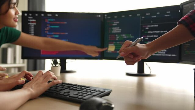 Slow motion back end software developer engineer for computer programming working together on debugging writing computing code, solving complex algorithms display on monitor in office. Burgeoning