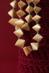 Straw necklace on a red background. Straw weaving. Small depth of field