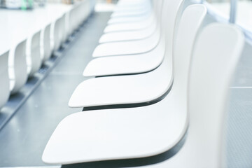 A long row of white plastic chairs with space to copy. High quality photo