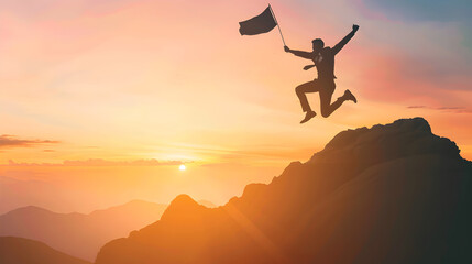 Silhouette of a standing happy man enjoying life and jumping on mountain against orange sunset sky and with flag on mountains background Concept of Success in life.