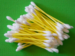 Cotton Swab Array. White-tipped swabs with yellow stems, green backdrop.