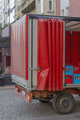 Open Curtain at Red Beverage Delivery Truck Parked at Street in Capital City