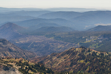 view from the mountains in to the valley of lassen volcanic national park with a beautiful road 