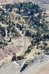 view from the mountains in to the valley of lassen volcanic national park with a beautiful road 