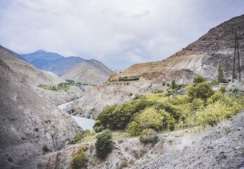 Road and river in a rocky gorge made of colored rocks in the Fan Mountains in Tajikistan