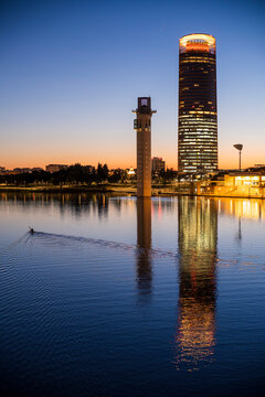 Canoeist on the Guadalquivir river in front of Schindler and Sevilla towers, Seville, Spain.