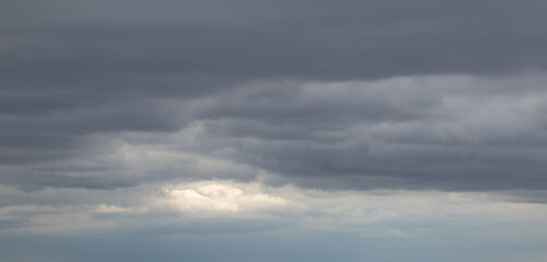 Dark, gloomy clouds with peek of sunlight