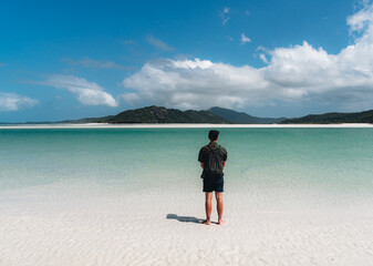 Young Caucasian Man tourist traveler standing at whitehaven beach, Queensland, Australia.