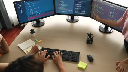 Slow motion back end software developer engineer for computer programming working together on debugging writing computing code, solving complex algorithms display on monitor in office. Burgeoning