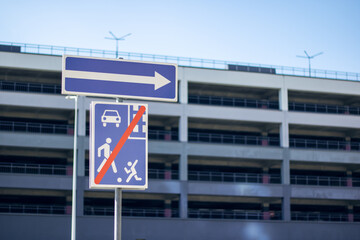 Obraz premium Skyblue and white sign directs right, showing way to building facade
