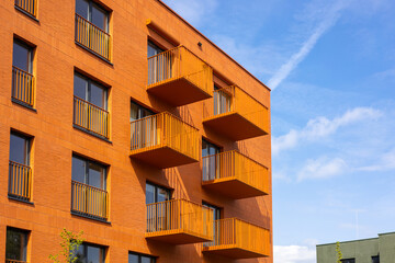 Modern apartment buildings on a sunny day with a blue sky. Orange Facade of a modern apartment...