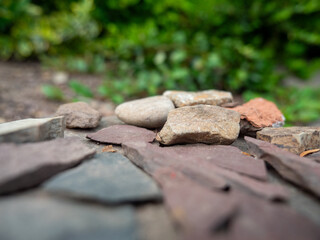 Various stones lying on the ground with a narrow plane of focus and green background