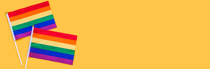 LGBT rainbow flag flat lay on yellow color background. gay marriage, human rights, june parade, lgbtq proud history month concept, coming out day. top view, place for text or logo