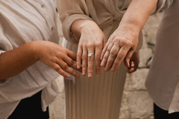 Three adult female hands of different ages. Family values concept. Grandmother mother and...