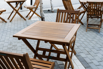 Outdoor furniture set, wooden folding tables and chairs on sidewalk