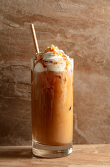 Iced caramel latte topped with whipped cream and caramel sauce.