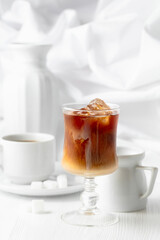 Iced coffee with cream and cup of black coffee.
