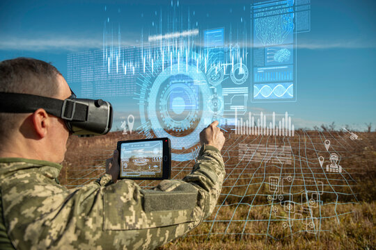 AI technology in the army. Warfare analytic operator using vr virtual reality glasses checking coordination of the military team with tablet device augmented reality operating troops outdoors