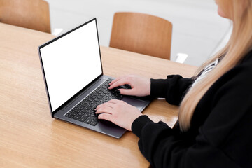 Young white woman working on computer with blank copy space screen on table in home office. close up female businesswoman hands typing text, surfing internet on modern laptop. mock up, front view