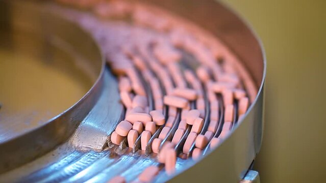 tablet making process in a pharma factory. Pharmaceutical manufacturing tablet pill production line. medicine drug tablets capsule on medical equipment. medicine tablets moving in a machine.