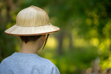 A child in a straw hat.A trip to the rainforest.A quest in the jungle.