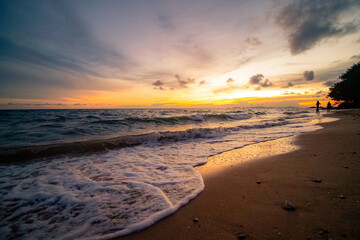 Aerial panorama of Thailand's verdant with blue and aquamarine the sea, and clouds shining by sunlight in the background.
