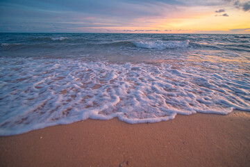 Aerial panorama of Thailand's verdant with blue and aquamarine the sea, and clouds shining by sunlight in the background.
