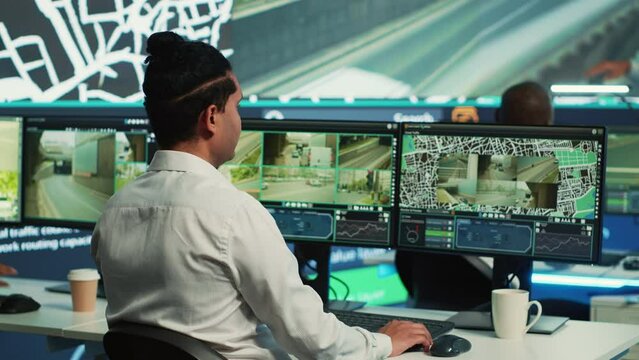 Team of employees monitoring delivery trucks with gps coordinates on satellite navigation, tracking orders with awb shipping system. Operators working in control center. Camera A.