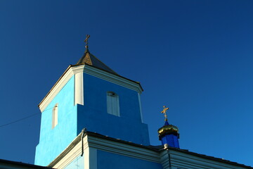 A blue and white building with a gold statue on top