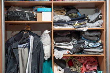 Messy closet. Clutter in the wardrobe with clothes © TSViPhoto