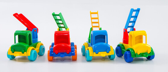 Plastic toy multi-colored truck on a white background. Group of fire trucks.