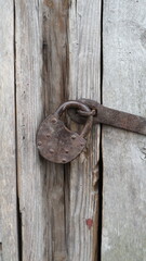 A metal padlock on the barn door. Old padlock.