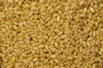 Heap of raw bulgur, close up. Healthy nutrition, vitamin cereals.