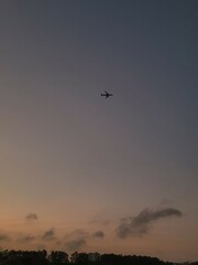 early morning sunrise, purple sky with an airplane