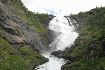 Fototapeta premium Raging waterfall Kjosfossen along the high mountain railway Flamsbana line inland from Flam Norway. The landscape of Sogn og Fjordane valley in Vestland county, Norway